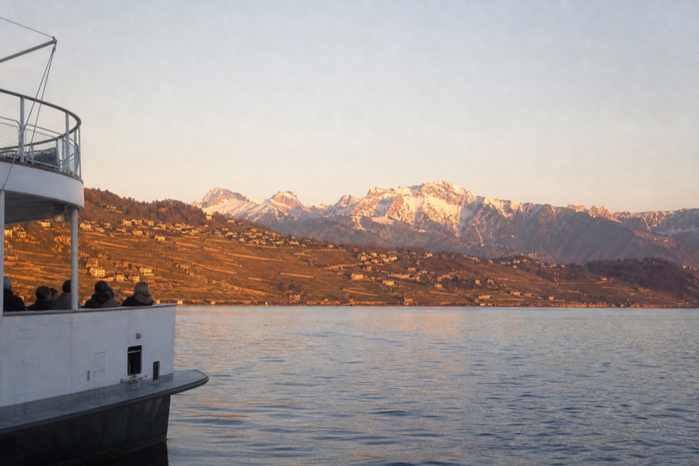 The Lavaux vineyard terraces above Lake Geneva seen from the water near Lausanne-Ouchy, the Alps across the lake