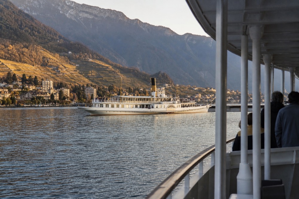 A CGN cruise boat on Lake Geneva near Montreux, the Swiss Riviera shoreline and Alps behind