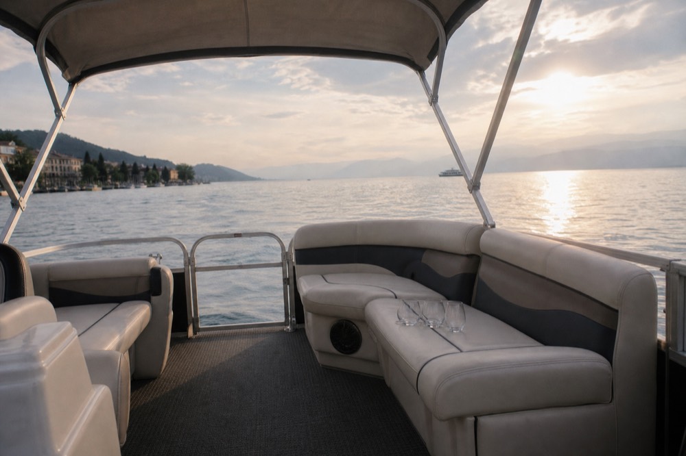 An open pontoon boat on Lake Geneva at golden hour off the Geneva lakefront, glasses set out on the deck