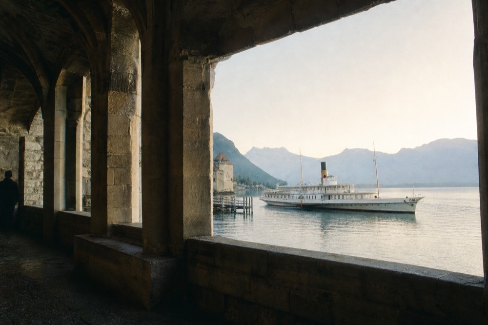 A vaulted stone hall inside Château de Chillon at Veytaux on Lake Geneva, tall pillars and small windows looking out to the lake