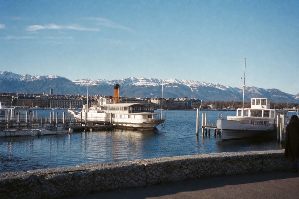 A CGN boat pier on the Geneva lakefront at Lac Léman, boats moored and the city waterfront behind