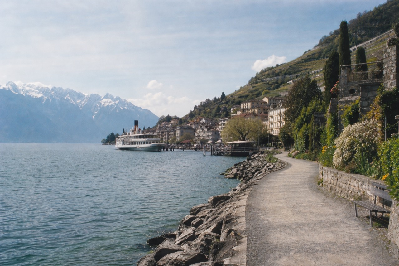 The Swiss Riviera shoreline of Lac Léman at Montreux, a lakeside promenade backed by vineyards and the Alps