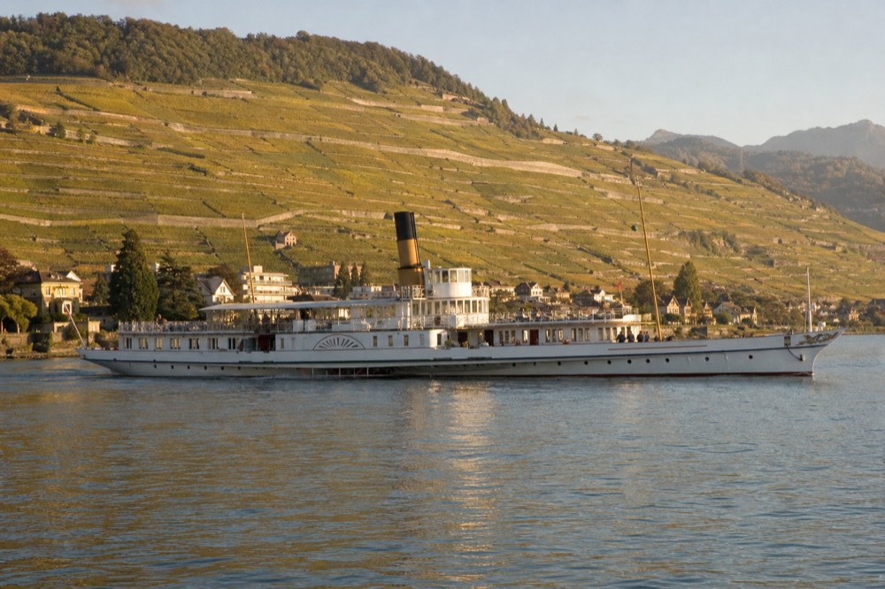 A Belle Époque paddle steamer on Lake Geneva off Vevey, the Lavaux vineyard terraces rising behind