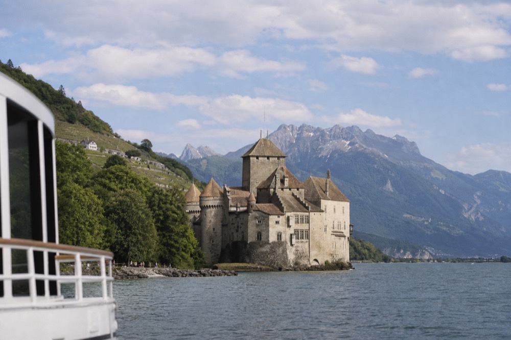The medieval Château de Chillon rising from the water of Lac Léman near Montreux, the Alps behind it