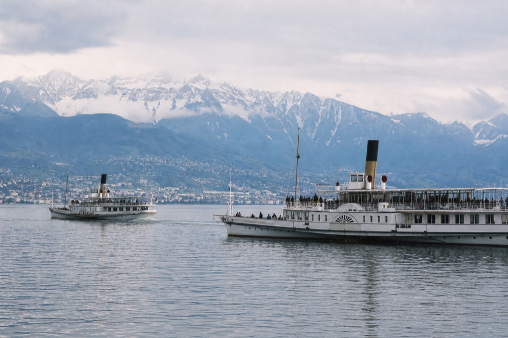 Two Belle Époque paddle steamers on Lac Léman near Vevey, the Riviera and the Alps beyond