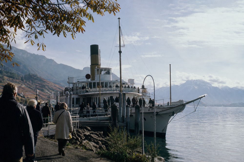 A CGN boat at the Lausanne-Ouchy waterfront on Lake Geneva, passengers boarding and the Alps across the water