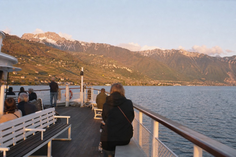 The open upper deck of a CGN boat on Lake Geneva off Lausanne-Ouchy, the Lavaux vineyard slopes across the water