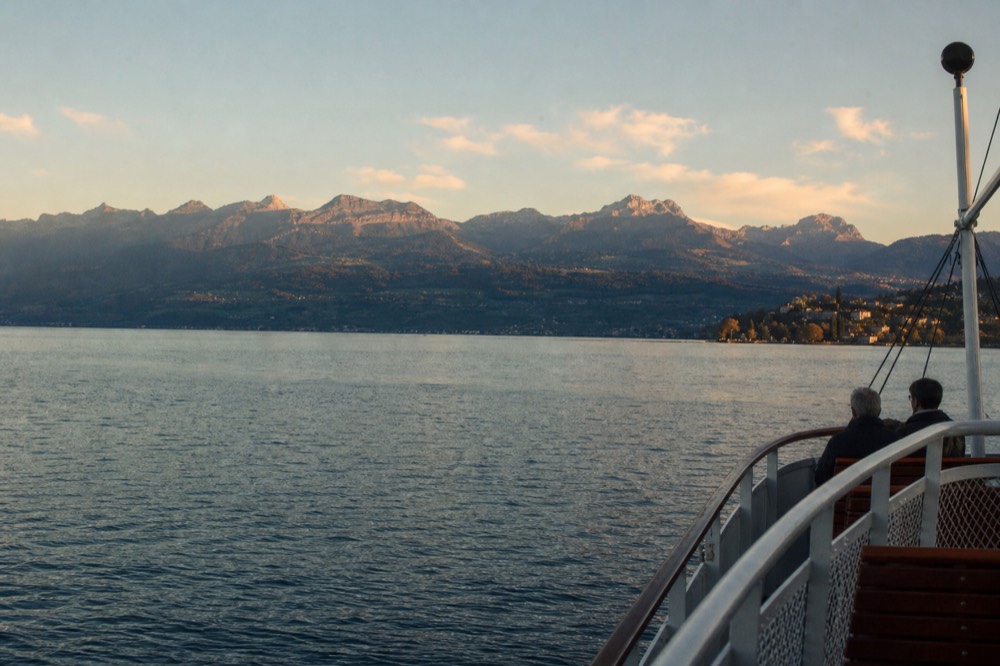 A wide view of Lake Geneva from a boat with the Alps across the water, on the route between Geneva and the eastern shore