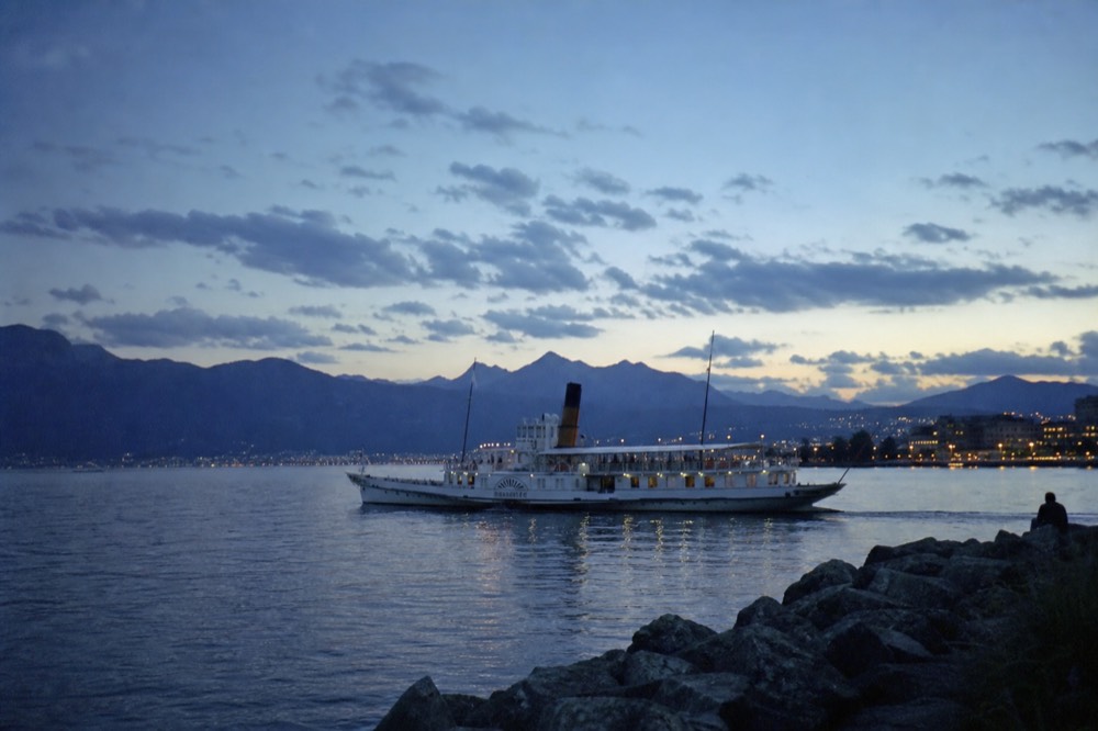 A Belle Époque paddle steamer on Lake Geneva near Lausanne under summer light with the Alps across the water