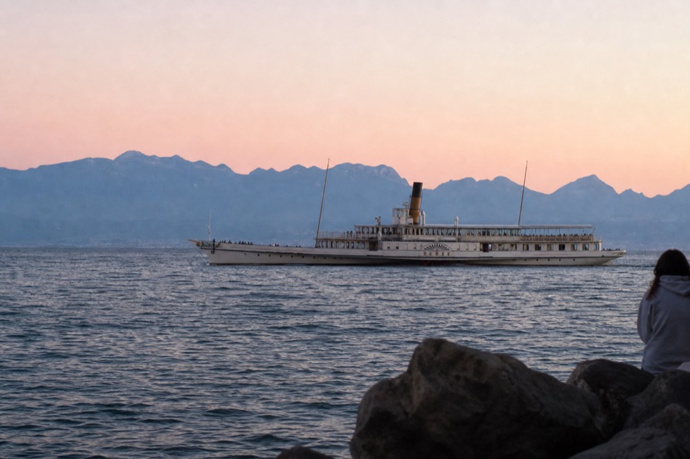 A Belle Époque paddle steamer on Lake Geneva off the Lausanne shore under summer light
