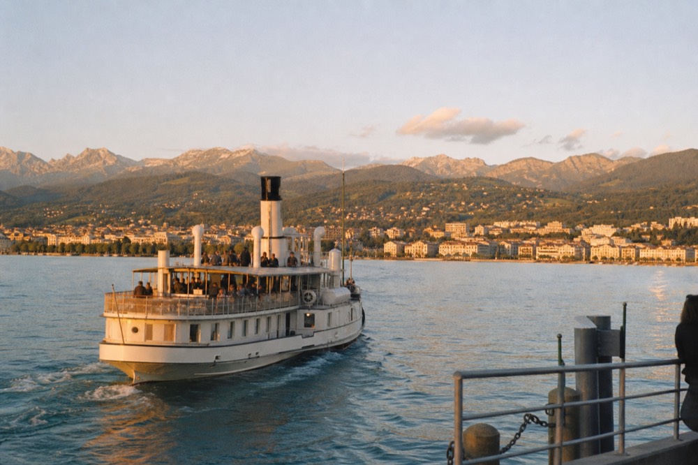 A CGN boat approaching Évian-les-Bains on the French shore of Lake Geneva, the Chablais hills behind the town