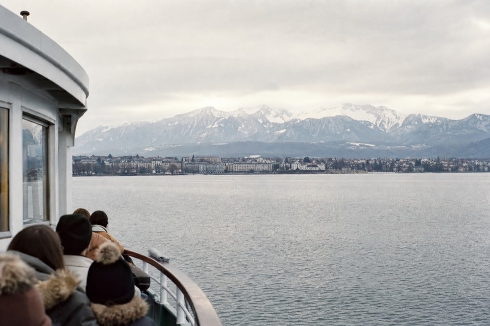 A CGN boat mid-crossing on Lake Geneva heading toward the French shore, the town of Évian and the Alps of Haute-Savoie ahead